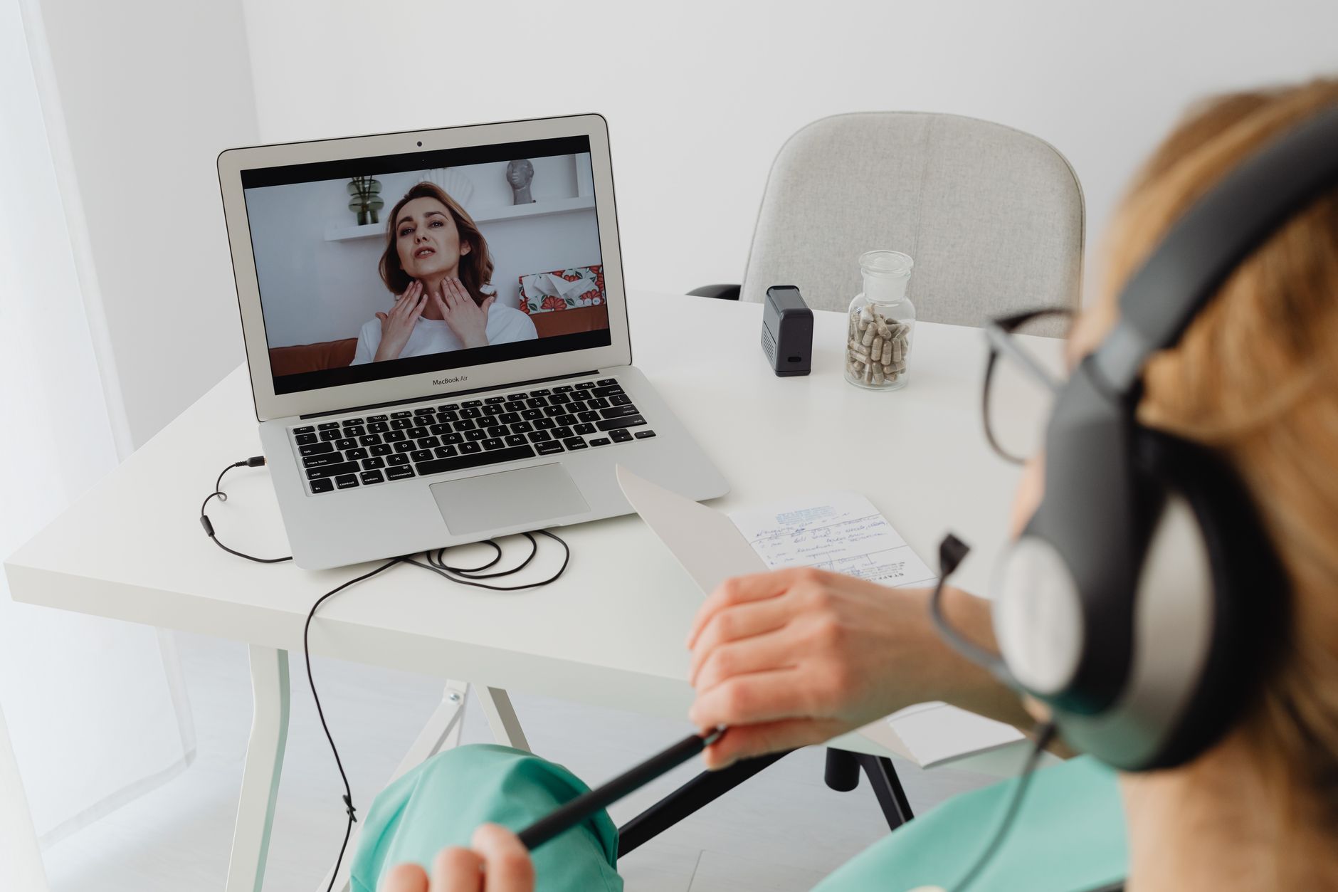 Nurse practitioner on a telehealth video call with a patient describing sore throat symptoms during an evening visit